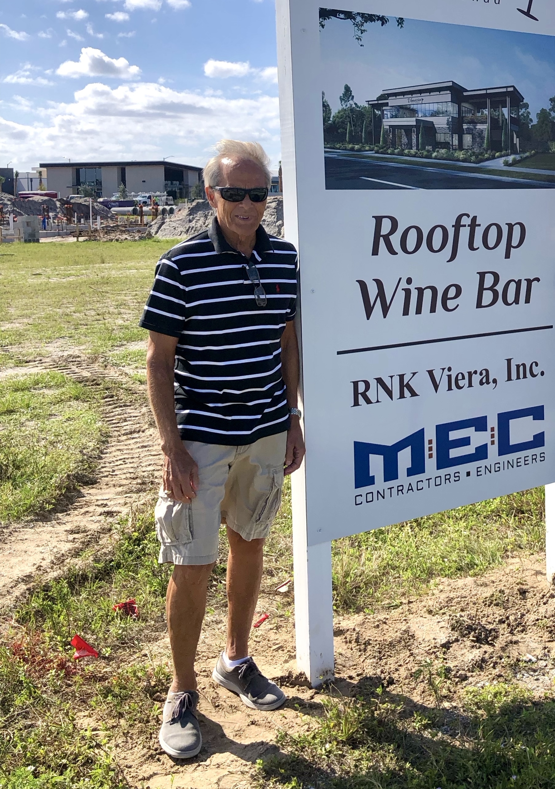 Viera Owner of rooftop wine bar next to sign
